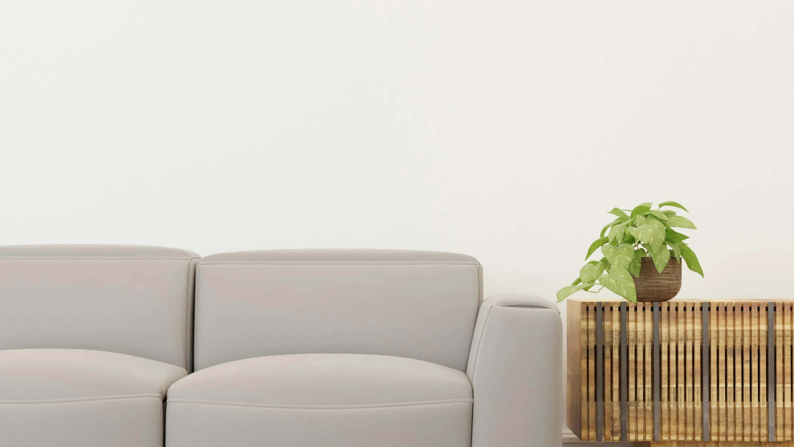 a gray couch sits in front of a wooden cabinet and a potted plant