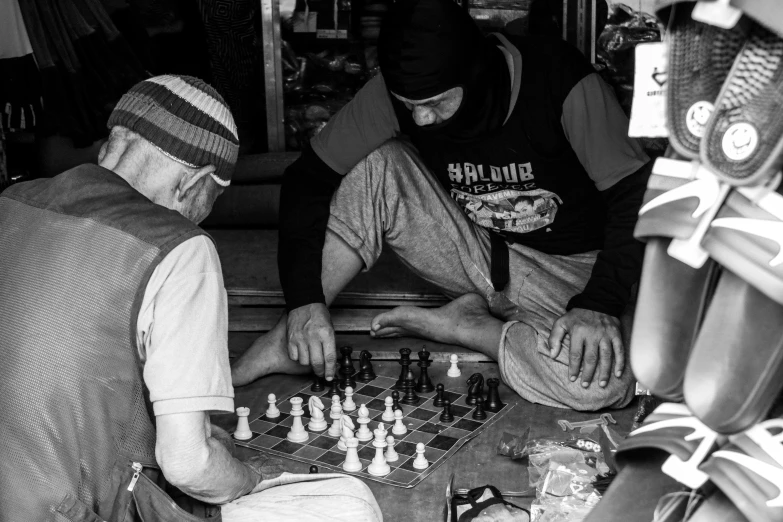 a group of men play chess together in a black and white po