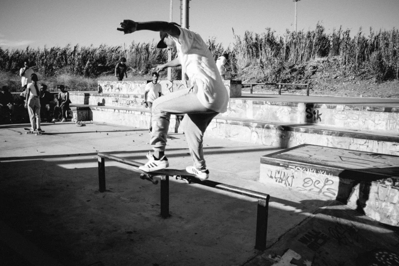 there is a man on the edge of a bench doing tricks on his skateboard