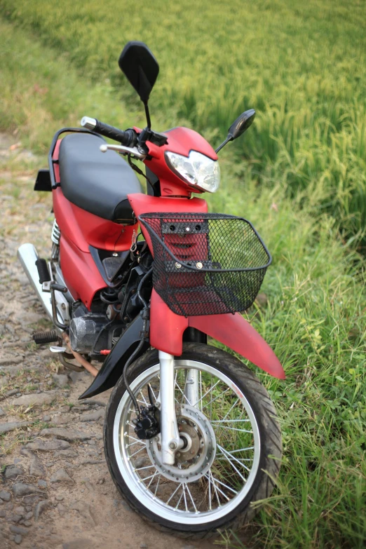 a red motorcycle sits on a dirt road