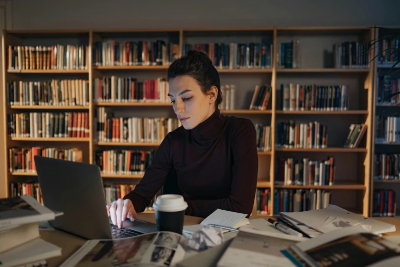 the woman is using a laptop computer in the liry