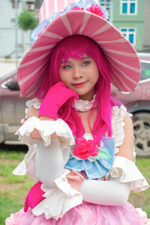 a girl wearing a pink hat and dress