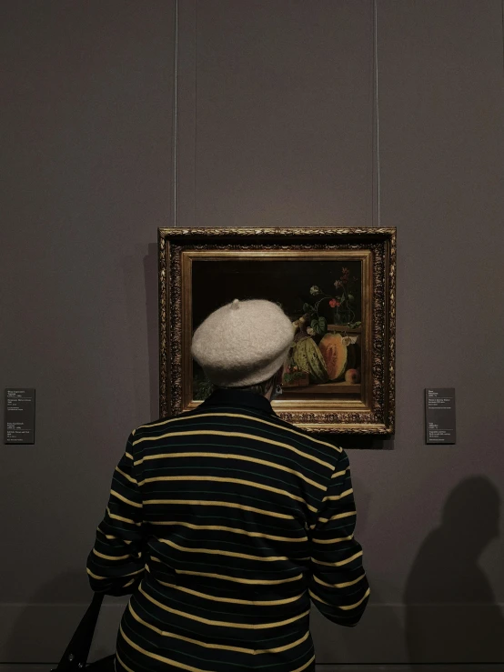 a person looking at some paintings on the wall