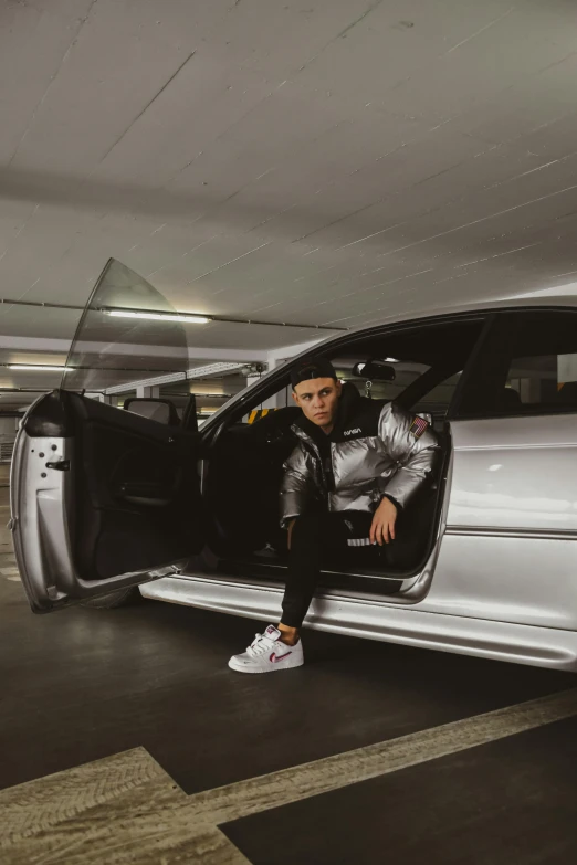 a person sitting inside a silver car in an airport