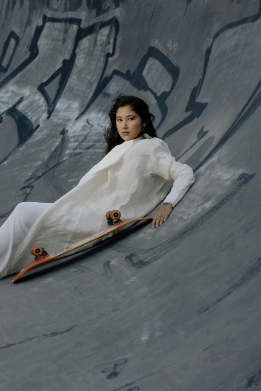 a woman sitting on a board at a skateboard park