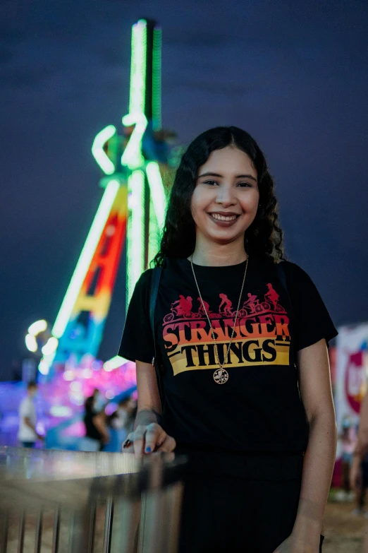 woman standing in front of fairground with dark sky