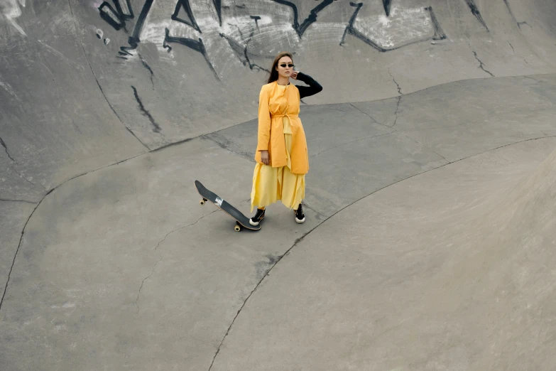 a woman in yellow is on the skateboard ramp