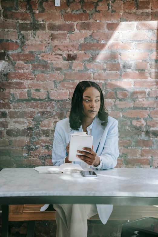 a person in business attire sitting at a table with a tablet