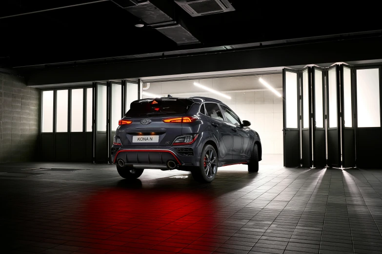 an suv parked in an indoor garage while red lights shine on the floor