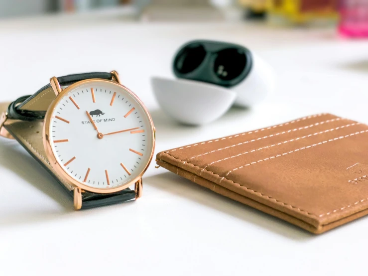 a leather card wallet, a watch and a cup