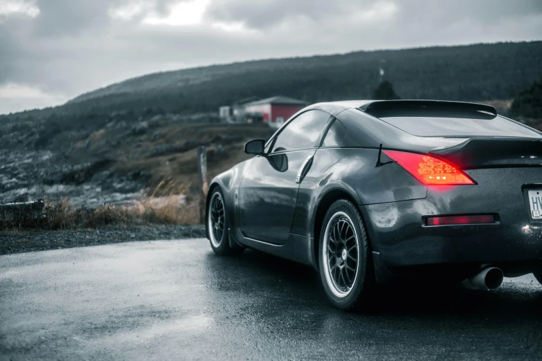 a black sports car parked in front of a hill