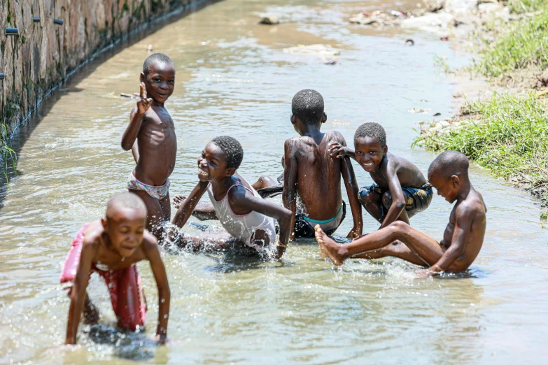 group of children playing in water at outdoor location