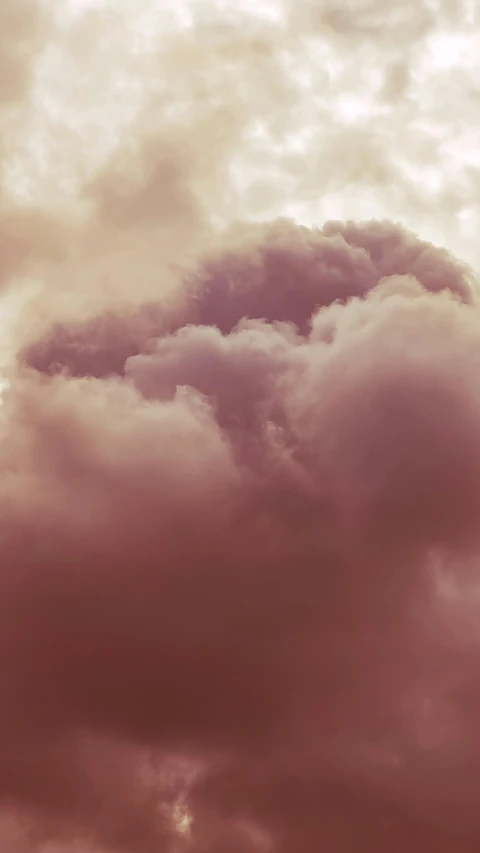 a plane in the distance flying through a cloudy sky