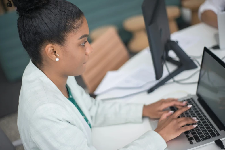 a girl works on her laptop at a desk