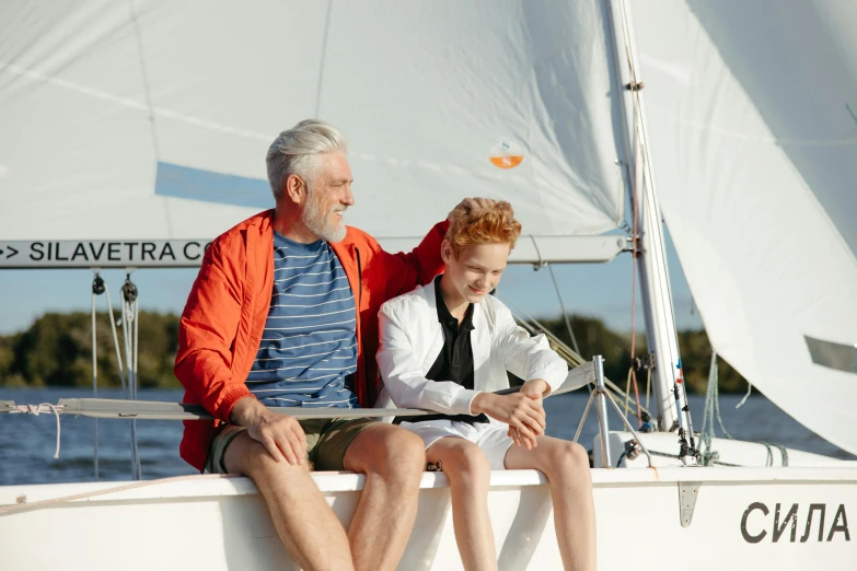 a woman and man are sitting on the back of a sailboat