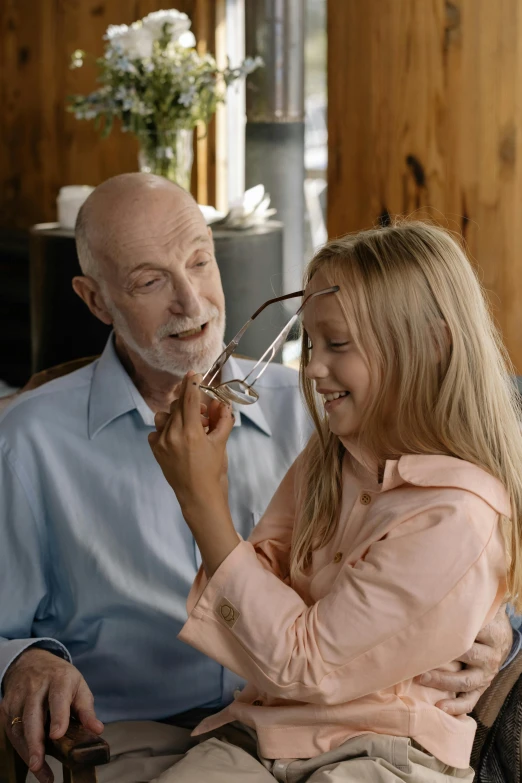 a man helps his granddaughter adjust the wire for her hands