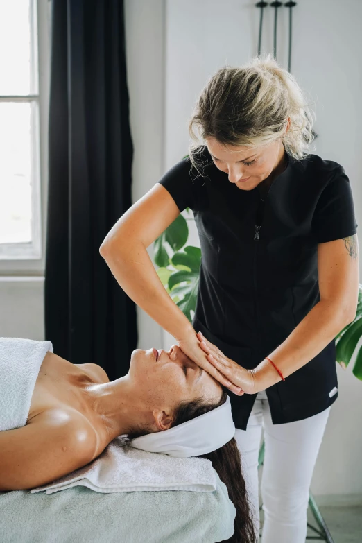 a woman getting a massage while getting her neck and back checked