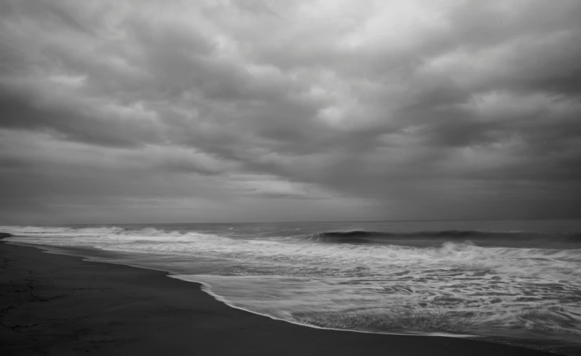 an ocean view of dark clouds and water