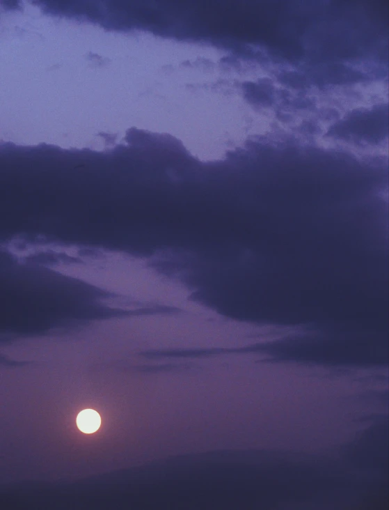 the moon is shown on a hazy night