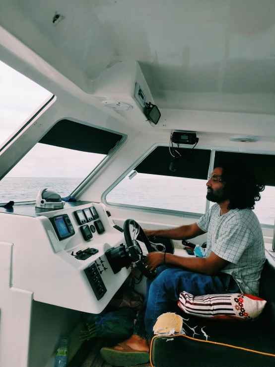 a man sits at the helm of a boat with electronic devices