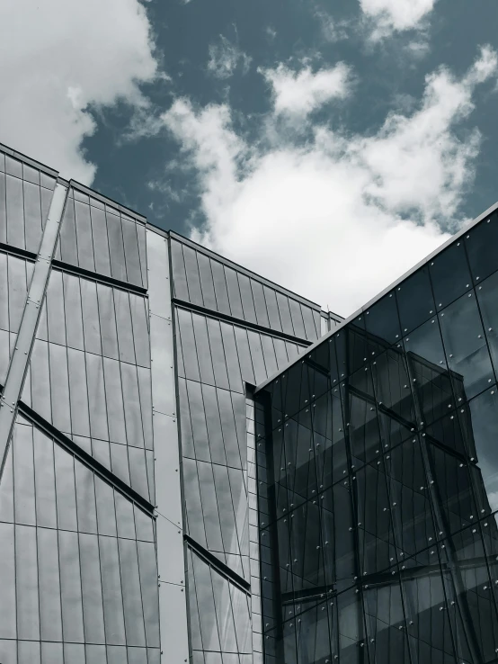 two very tall windows on a building near clouds