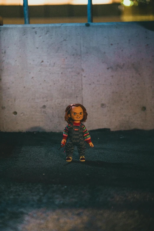 a stuffed doll sitting in front of an overpass