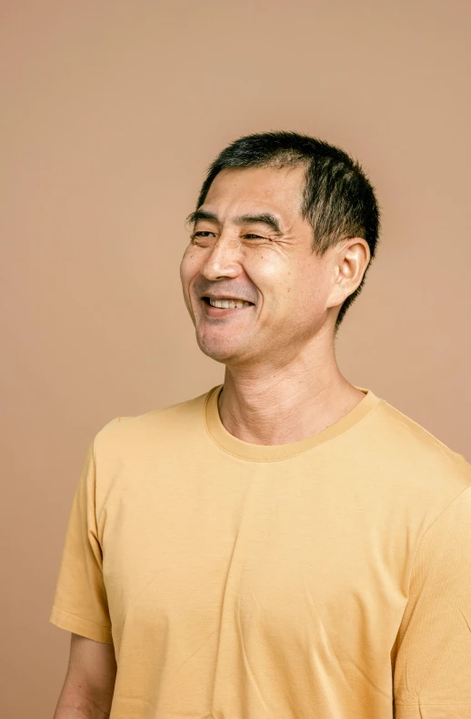 a smiling asian man with a silly look on his face