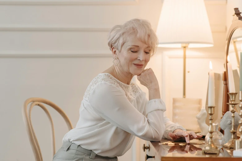 the older woman is doing her makeup in front of the mirror