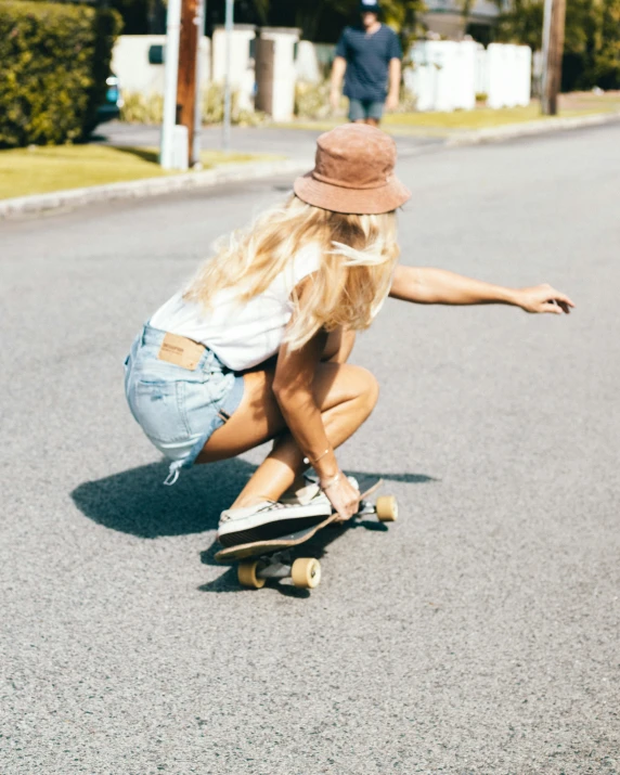 a woman riding on top of a skateboard down the middle of a street