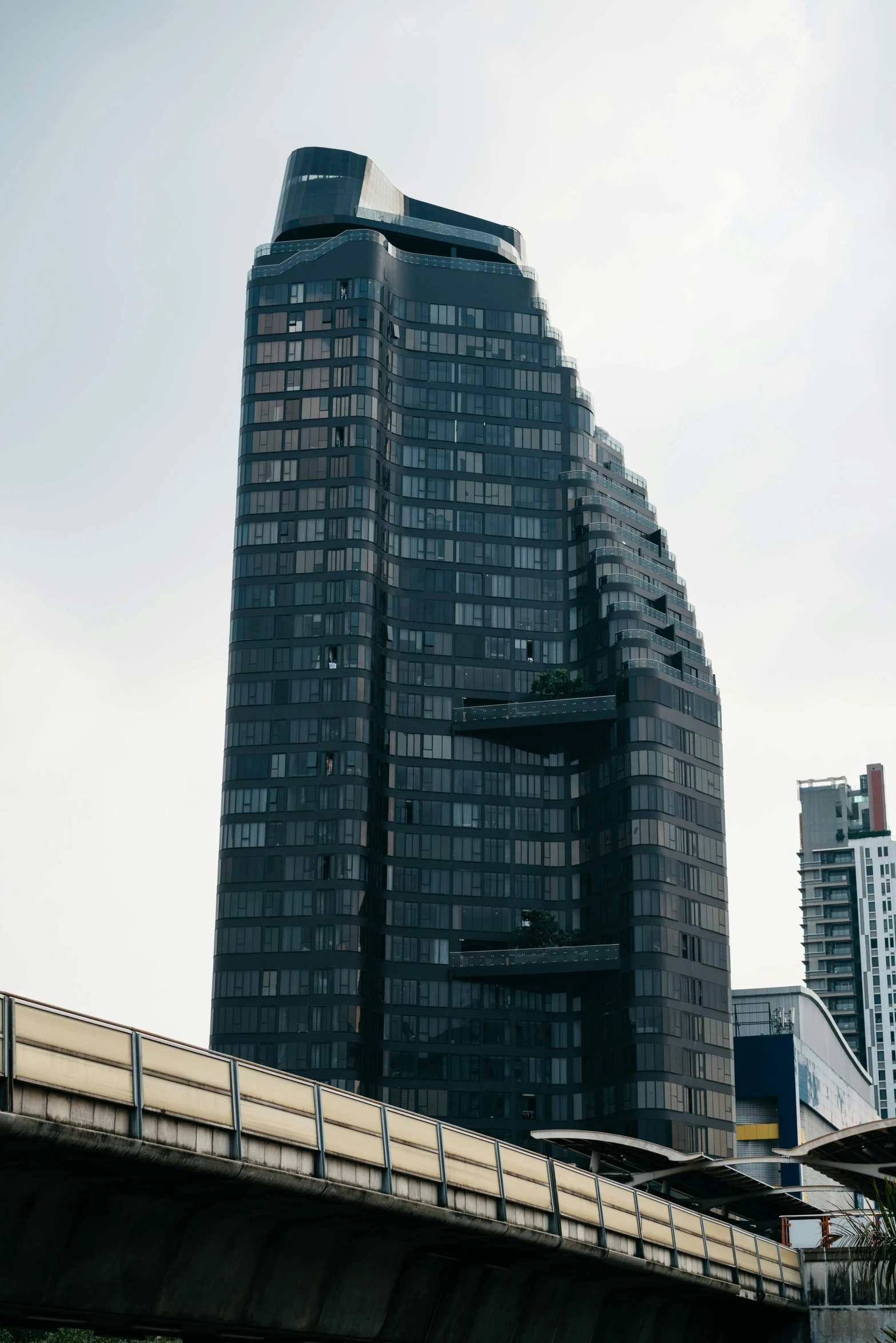 large, black buildings on a bridge and traffic lights