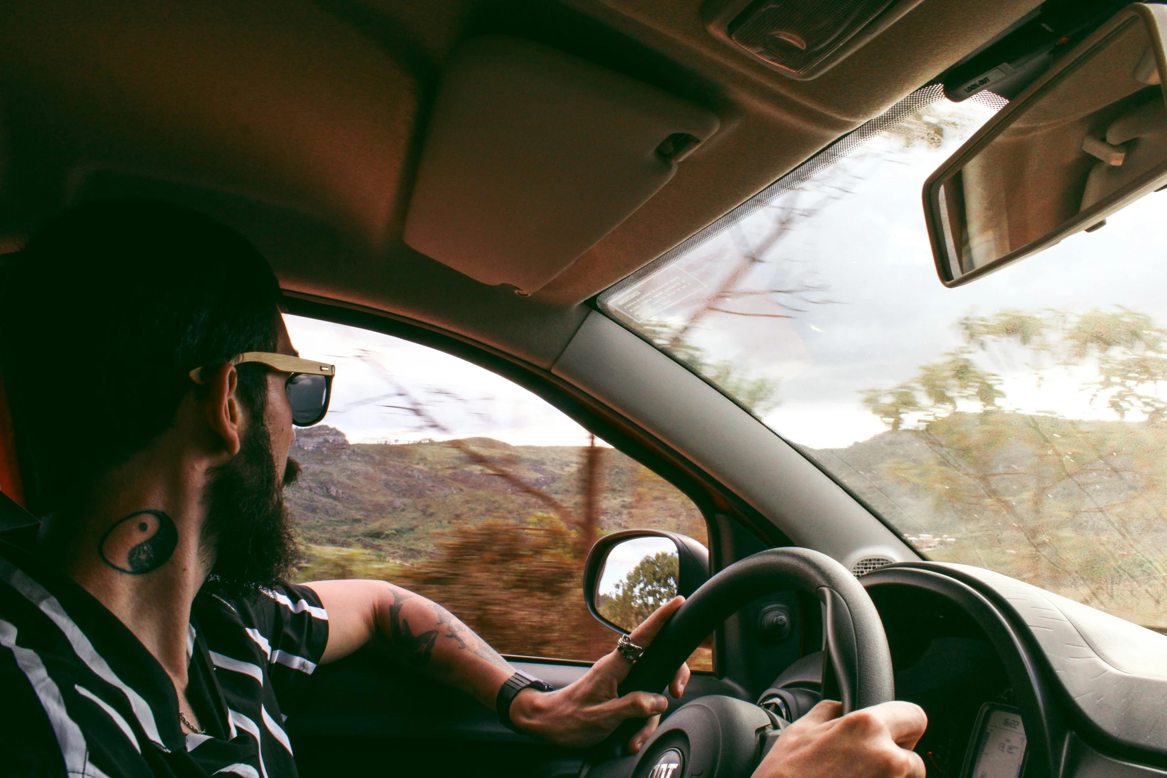 a man driving a car in a rural area