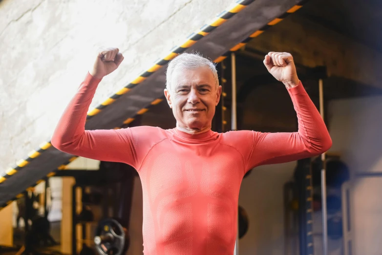 a man is shown wearing a red shirt and raising his arm