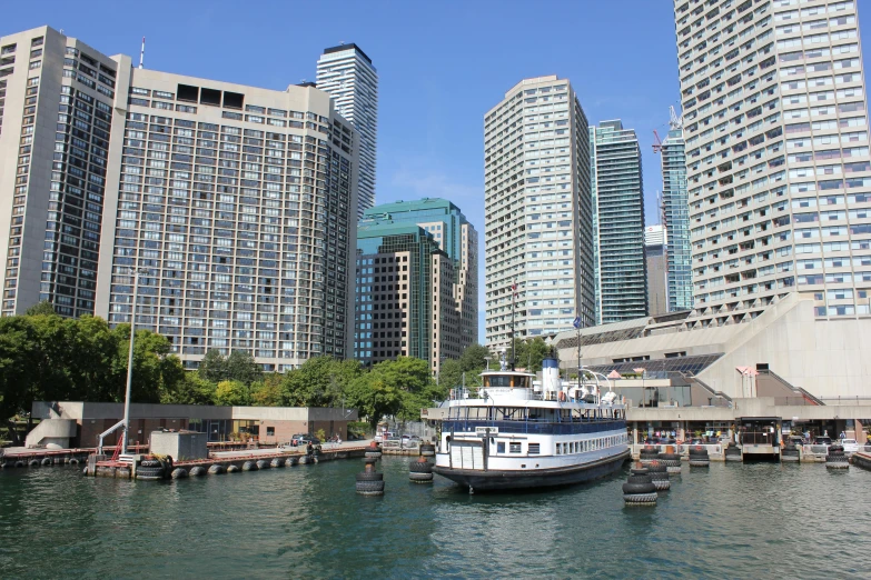 a river scene of boats at dock with buildings in the background