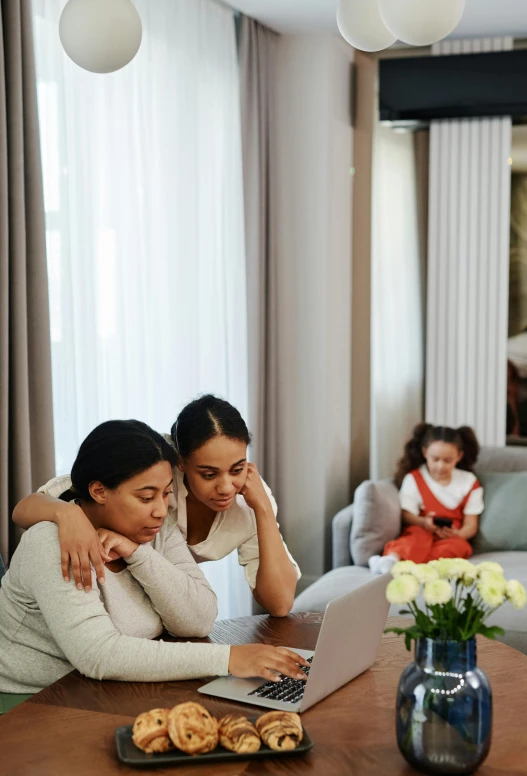 two women on laptop computer sitting next to each other