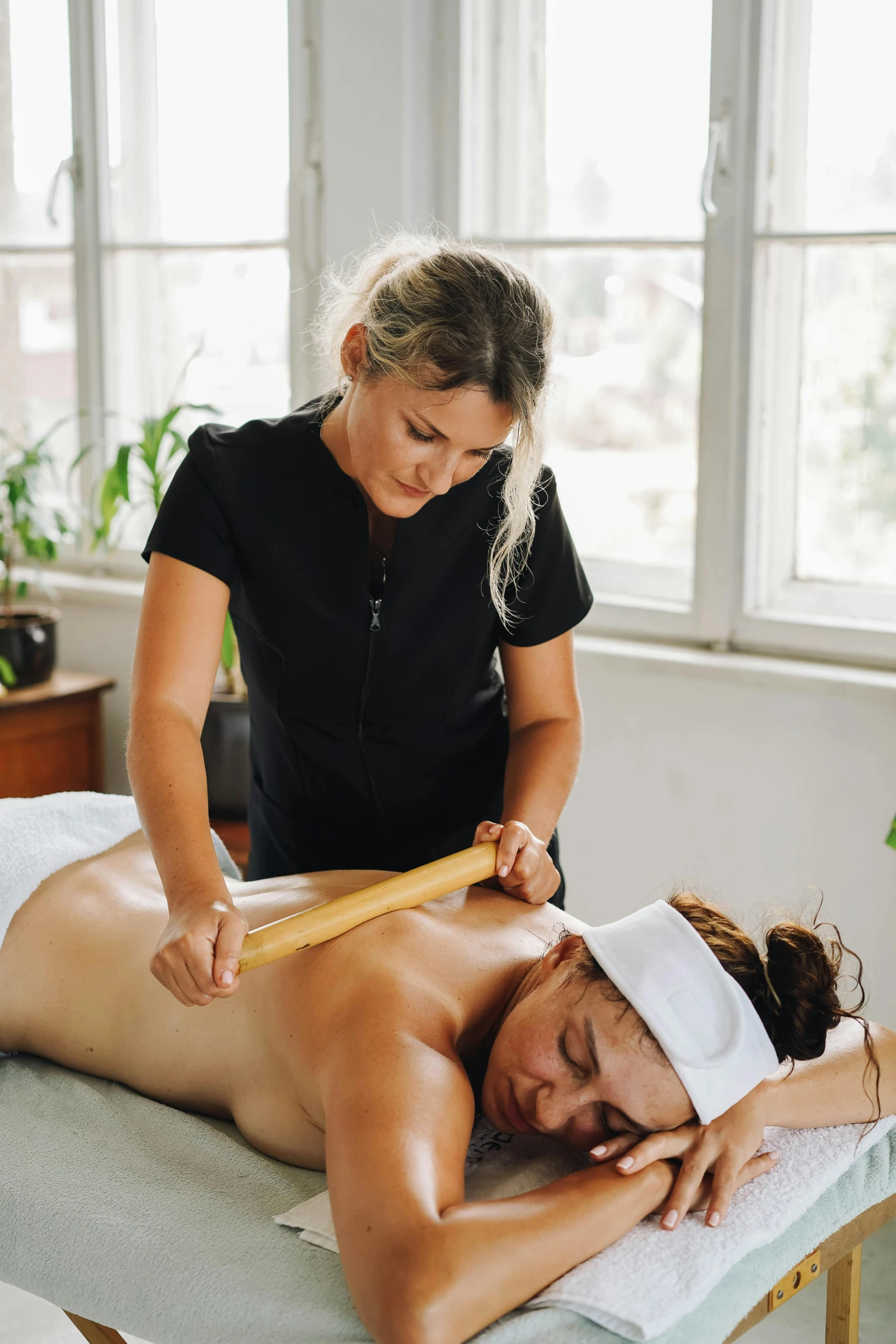 woman getting a back massage in front of a window