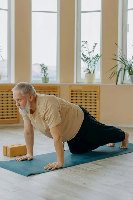 a man doing h up yoga in front of some windows