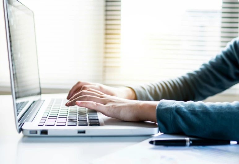 someone sitting at a desk with a laptop computer