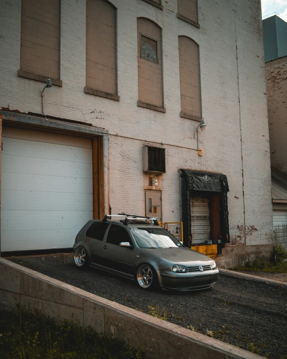 the car is parked in front of an old brick building