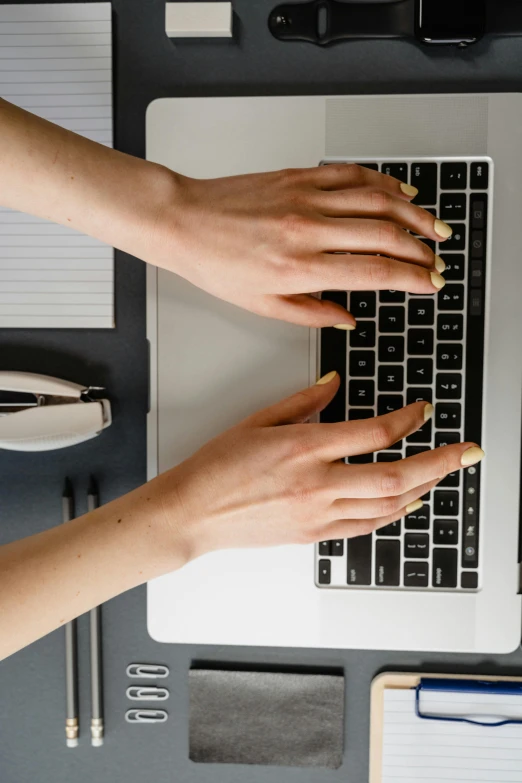 two hands are sitting on top of a laptop