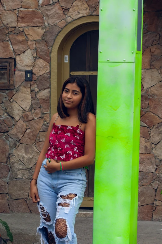 a girl leaning against a large pole