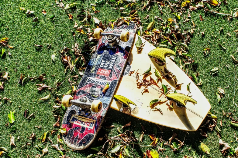 two skateboards laying on the grass, one is upside down
