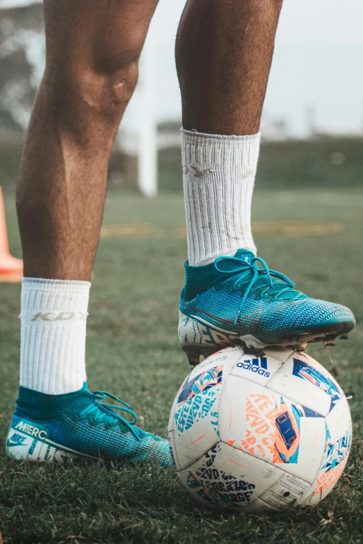 the feet of a soccer player who has just taken a ball off the ground