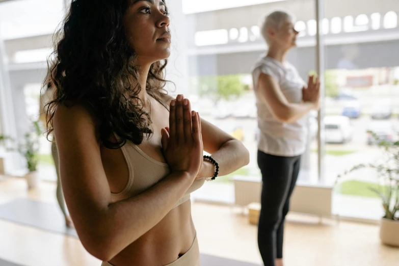 two women in s standing by an office building and doing yoga