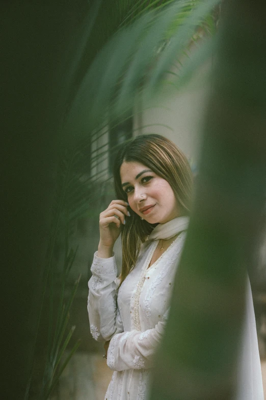 a beautiful woman wearing white looks at the camera