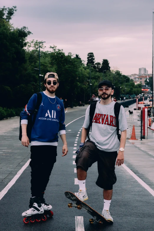 two men standing in the middle of a street with a skateboard