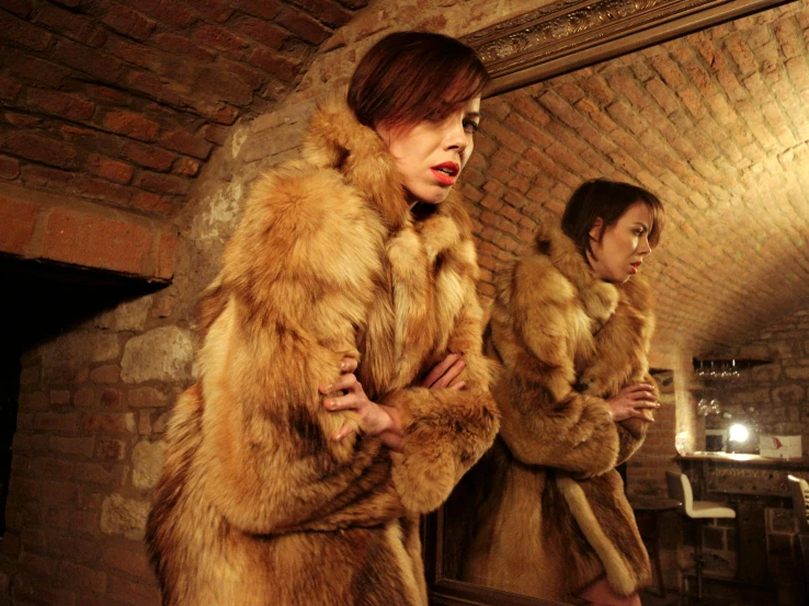 two women in coats with long furs are standing together