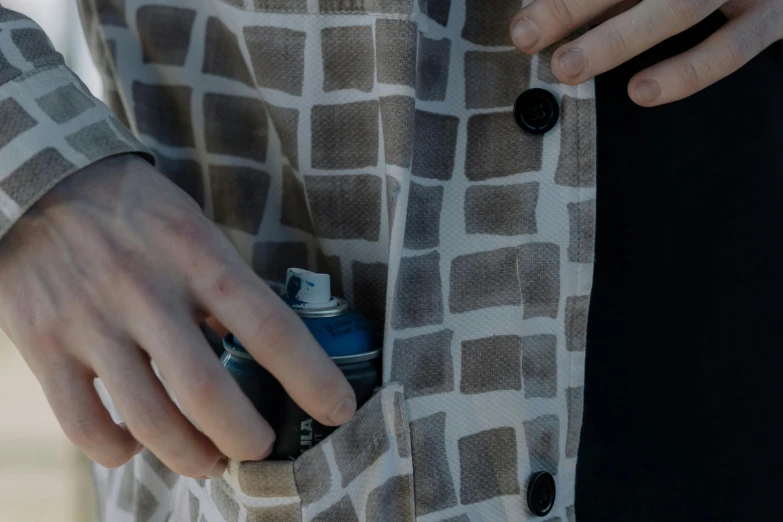 a close - up of a person's hand with a flask of water and lighter in his pocket