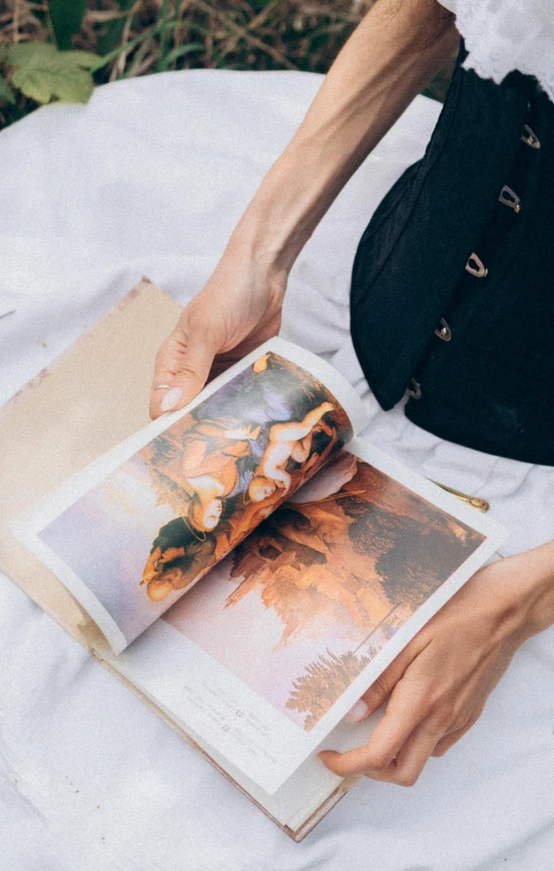 a woman sitting down while holding an open book