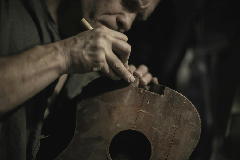 a man holding an old guitar in his hands