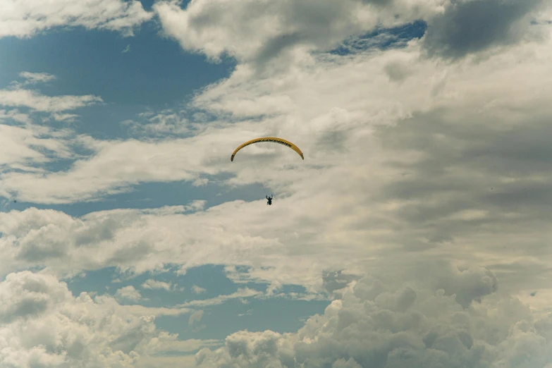 two kites flying in the sky on a cloudy day